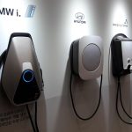 Quatre bornes de recharge pour véhicules électriques installées sur un mur blanc