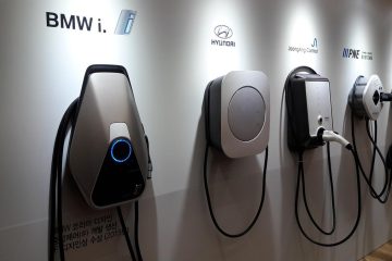 Quatre bornes de recharge pour véhicules électriques installées sur un mur blanc