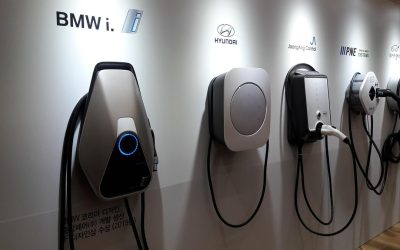 Quatre bornes de recharge pour véhicules électriques installées sur un mur blanc