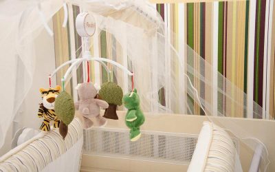 Berceau avec jouets suspendus et moustiquaire dans une chambre d'enfant