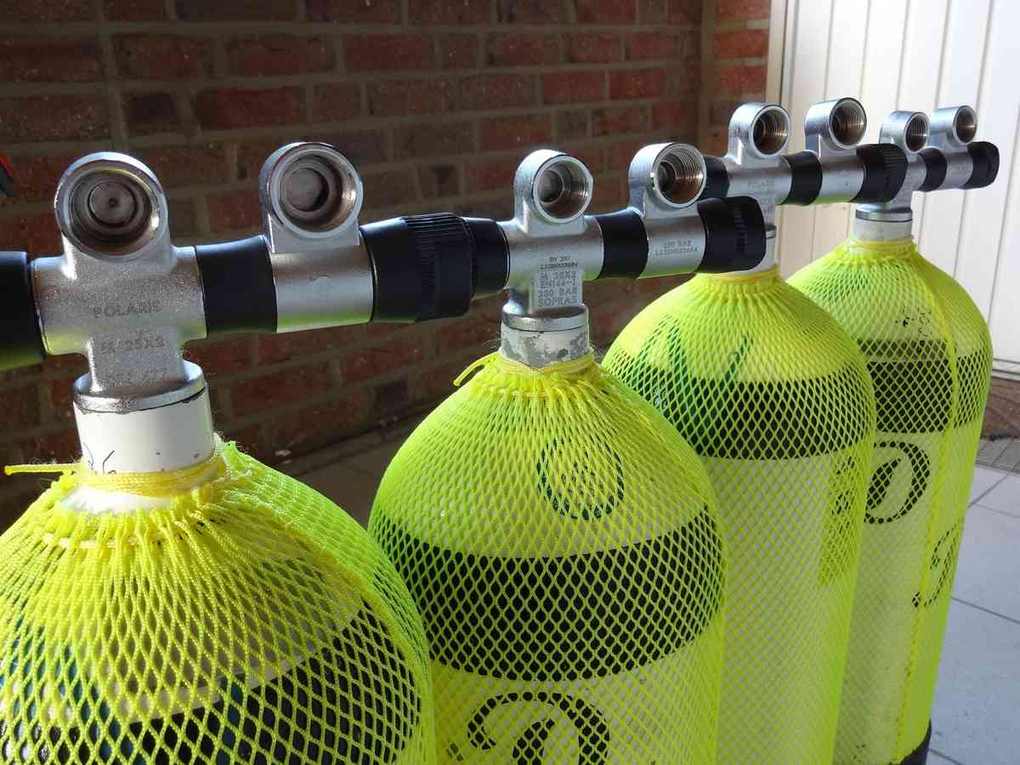 Cylindres d'oxygène avec masques connectés à un système de distribution près d'un mur en brique