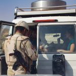 Un militaire ouvre la porte d'un véhicule à un occupant à l'intérieur
