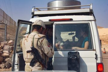 Un militaire ouvre la porte d'un véhicule à un occupant à l'intérieur