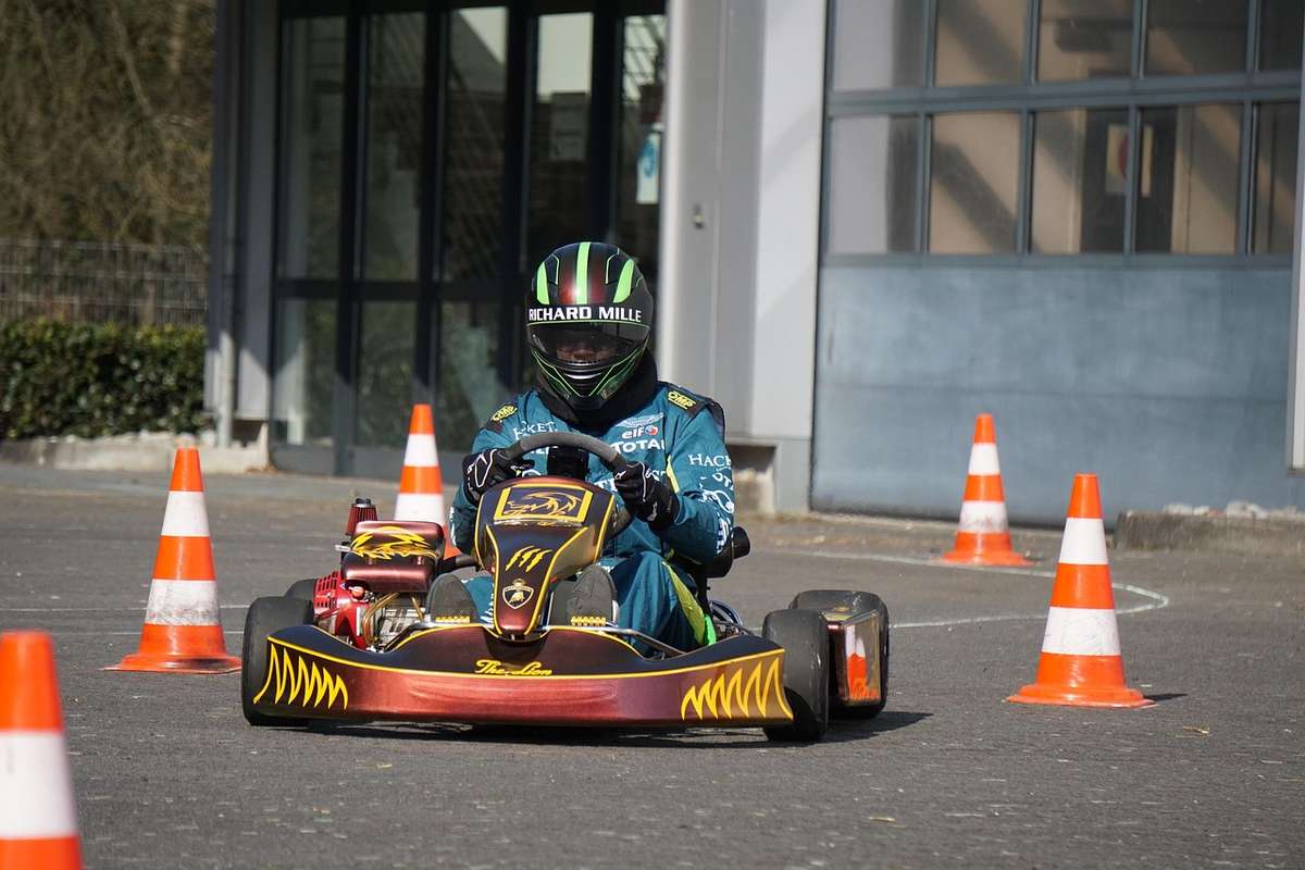 Un homme en karting avec des cônes de signalisation orange et blanche